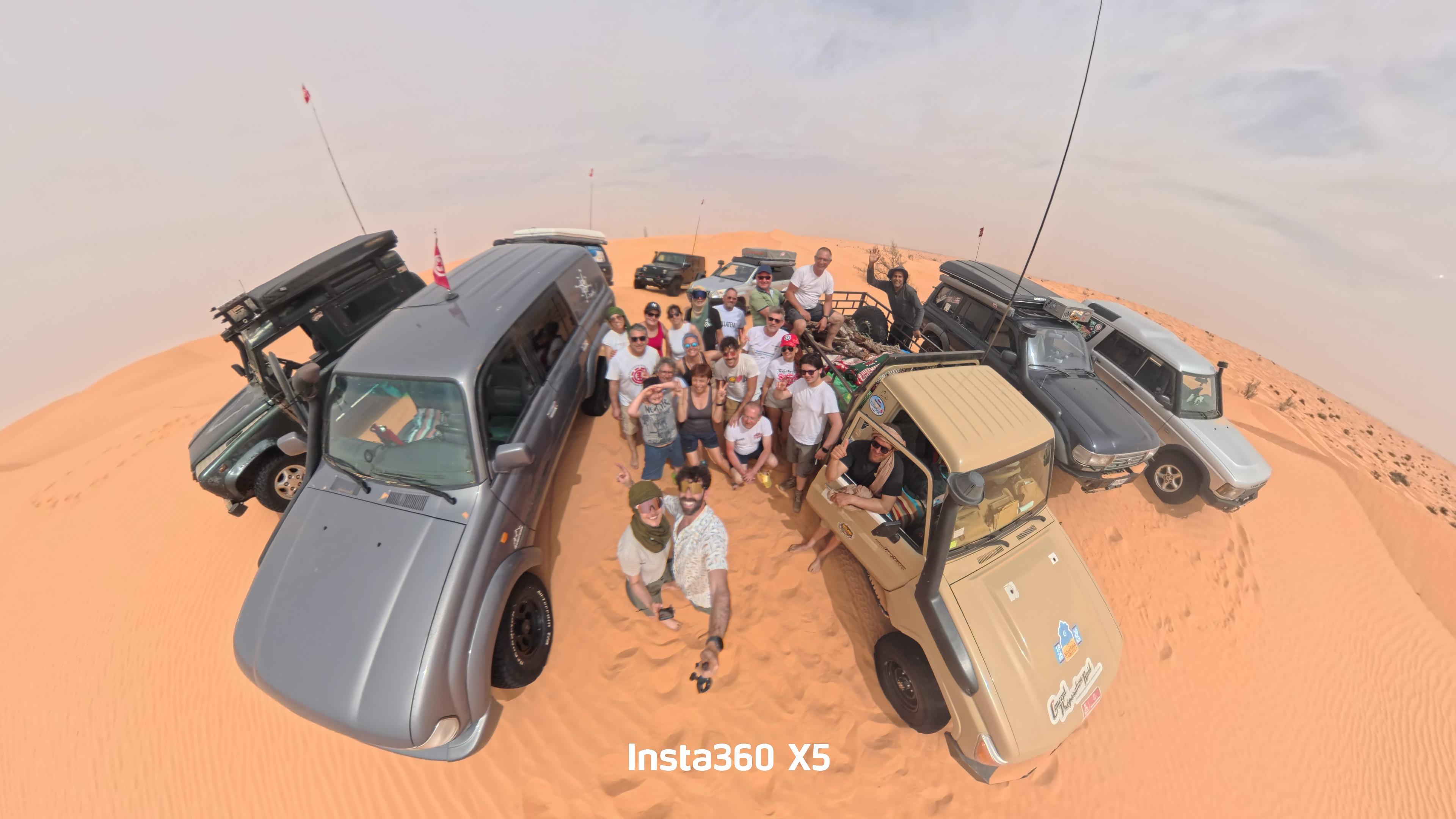 Groupe de voyageurs et véhicules 4x4 dans les dunes